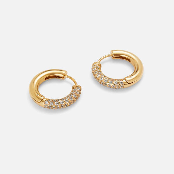 Gold pavé cubic zirconia huggie hoop earrings, pair on studio background